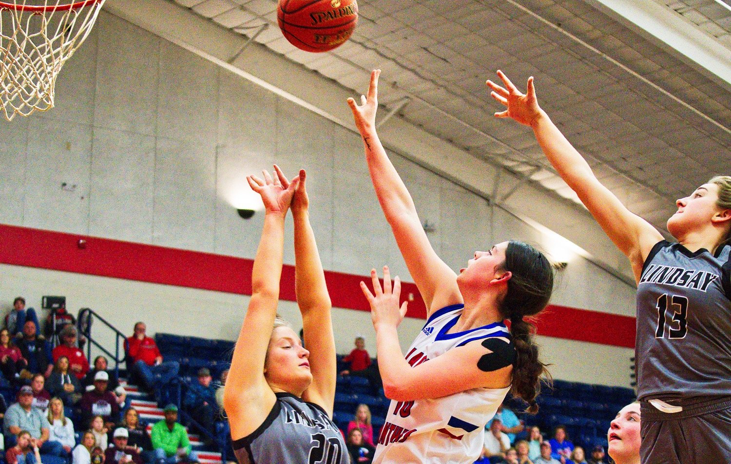 Autumn Whitten fires a contested jumper from short range. [see more shots, score prints]